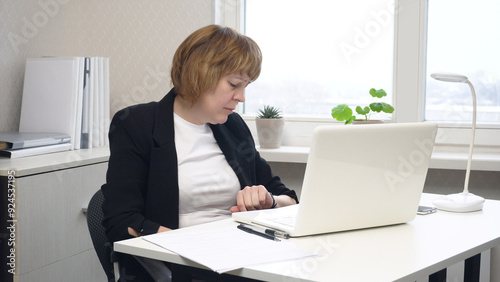 Female Office Worker Looking Tiredly at Clock