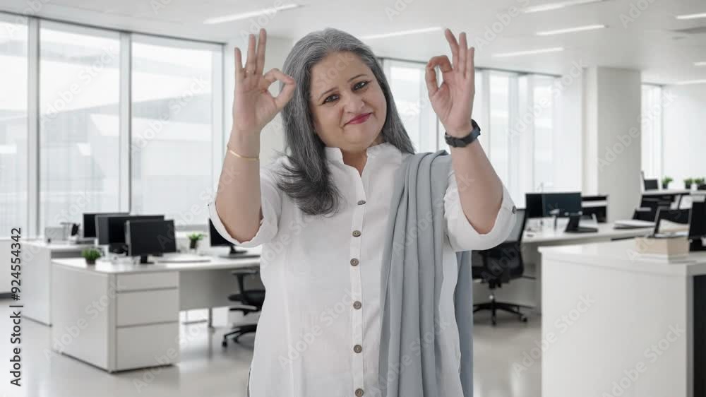 Happy Indian senior businesswoman showing okay sign Happy Indian senior businesswoman showing okay sign