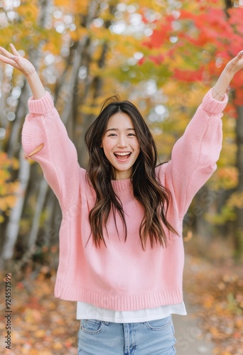 Joyful Young Woman Celebrating Amidst Colorful Fall Foliage in Urban Setting