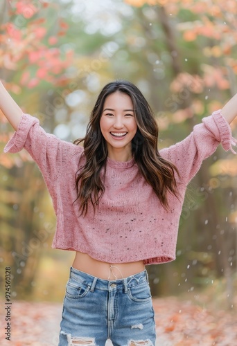 Joyful Young Woman Celebrating Amidst Colorful Fall Foliage in Urban Setting