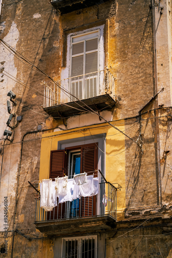 Rustic Urban Balcony with Laundry Hanging to Dry, typical facade view in Naples, Italy