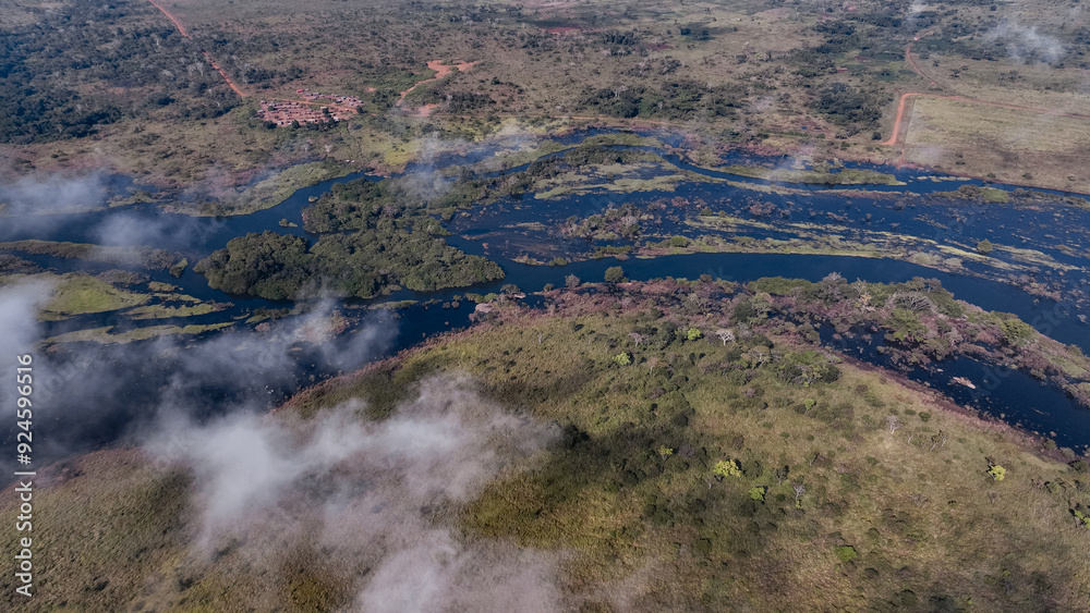Aerial view of the lush river delta in Angola showcasing winding waterways and rich vegetation during early morning mist Aerial view of the lush river delta in Angola showcasing winding waterways and rich vegetation during early morning mist
