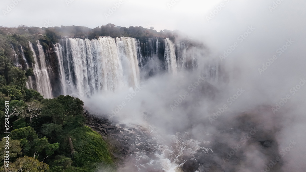 Kalandula Waterfall cascades majestically in Angola surrounded by lush greenery on a misty day Kalandula Waterfall cascades majestically in Angola surrounded by lush greenery on a misty day