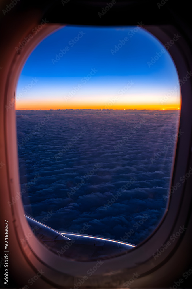 Fototapeta premium Row of airplane window. View during flight above clouds at sunrise.