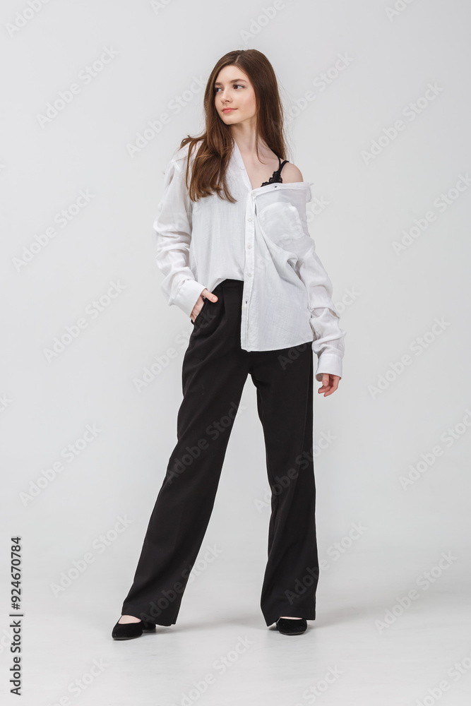 girl model in black tight-fitting dress poses in studio on white background girl model in black tight-fitting dress poses in studio on white background