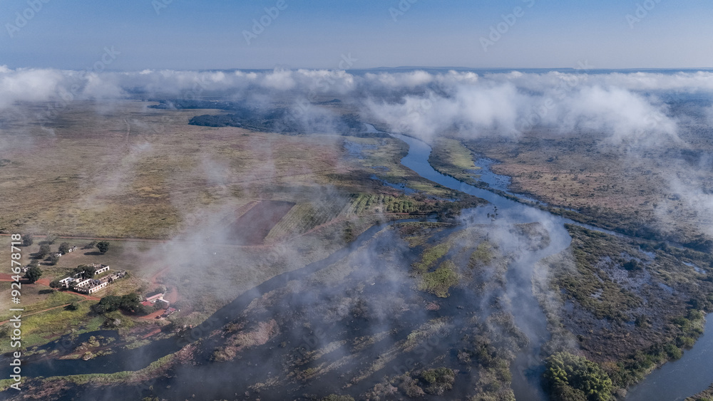 Aerial view of farmlands and winding river in Angola under a clear blue sky Aerial view of farmlands and winding river in Angola under a clear blue sky
