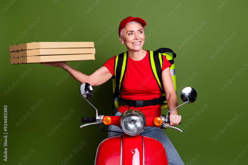 Photo of pensioner lady delivery service thermo bag scooter pizza look empty space dressed red uniform isolated on khaki color background Photo of pensioner lady delivery service thermo bag scooter pizza look empty space dressed red uniform isolated on khaki color background