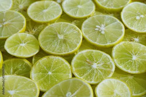 Lime slices texture background. Close-up lime slices texture with a green and yellow theme. Citrus, sour ingredients, fresh fruit, juicy texture, seeds concepts. Abstract background of yellow limes.