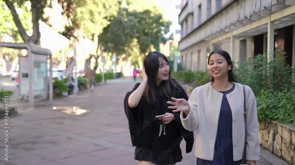 A slow-motion video capturing a young Taiwanese woman and a South Asian woman walking and chatting amiably on a public road near a university in Taipei's Da'an District. A slow-motion video capturing a young Taiwanese woman and a South Asian woman walking and chatting amiably on a public road near a university in Taipei's Da'an District.