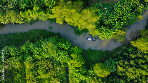  A small wooden boat in a river surrounded by nature, in Vietnam, Asia, seen from above 