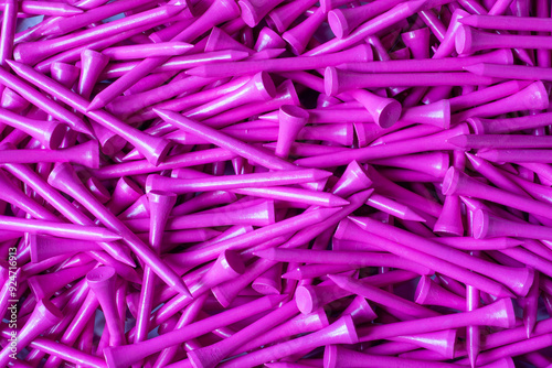 A large pile of neon pink wooden bamboo golf tees in a box