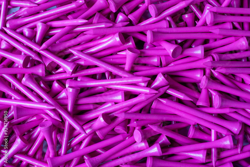 A large pile of neon pink wooden bamboo golf tees in a box