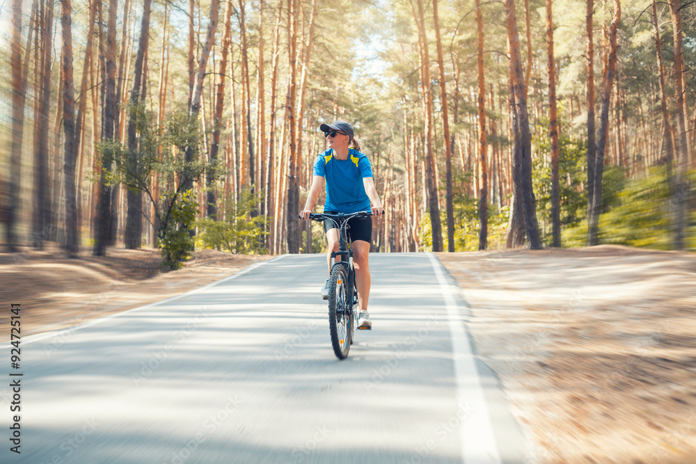 woman cyclist rides in the forest on a bike. woman cyclist rides in the forest on a bike.