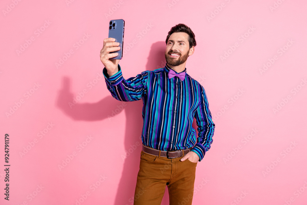 Photo of attractive elegant man wear trendy striped clothes hold gadget make video selfie isolated on pink color background Photo of attractive elegant man wear trendy striped clothes hold gadget make video selfie isolated on pink color background