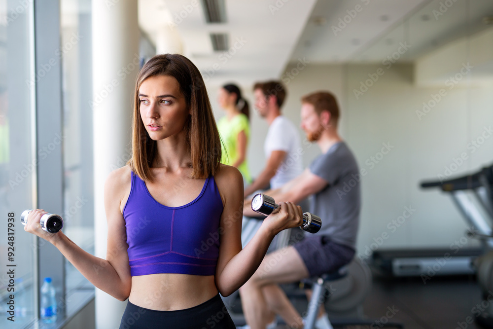 Happy smiling fit fitness girl lifting dumbbell in the morning in modern gym to stay healthy. Happy smiling fit fitness girl lifting dumbbell in the morning in modern gym to stay healthy.
