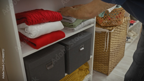 Man organizing colorful clothes in a modern, well-ordered wardrobe photo