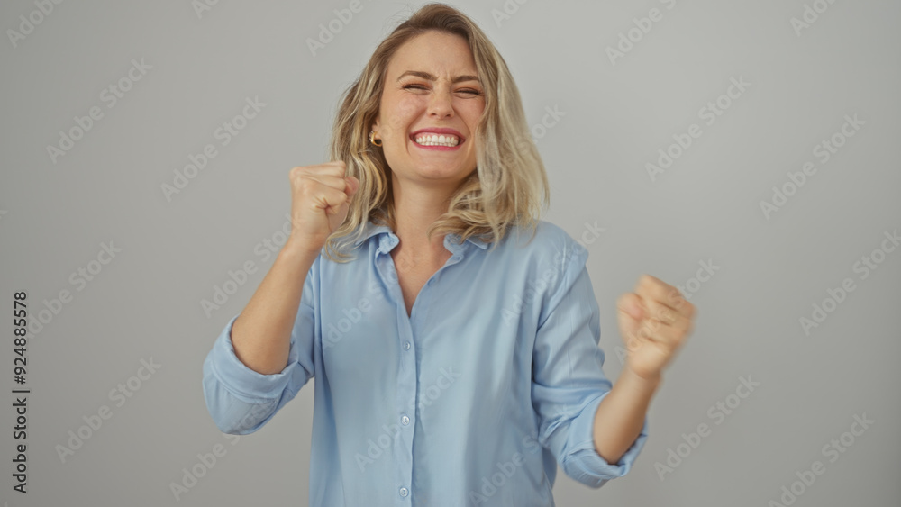 Excited young woman celebrating success with clenched fists against a white background Excited young woman celebrating success with clenched fists against a white background