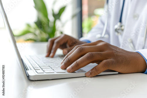 Doctor Typing on Laptop Keyboard in Office