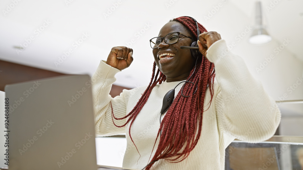 Joyful african american woman with braids celebrating success at her ...