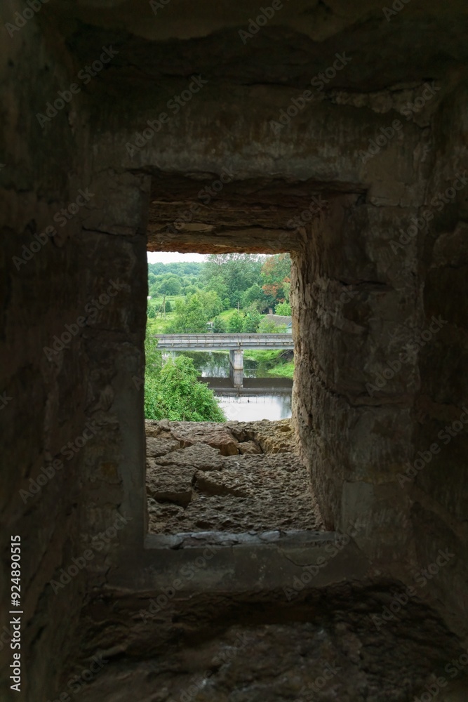 Old Ladoga, Russia, July 8, 2024. An embrasure in the fortress wall overlooking the bridge. Old Ladoga, Russia, July 8, 2024. An embrasure in the fortress wall overlooking the bridge.