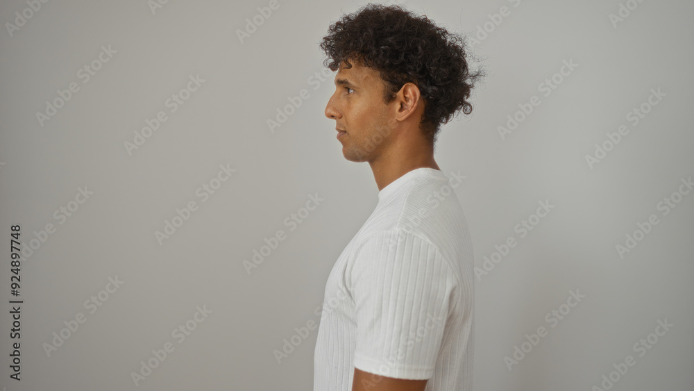 Young hispanic man in a white shirt standing against an isolated white background Young hispanic man in a white shirt standing against an isolated white background