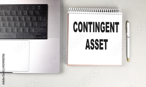 Fotografie CONTINGENT ASSET text on notebook with laptop, mouse and pen