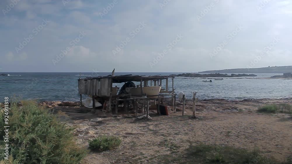 Typical wooden dry docks of Es Pujols to protect small fishing boats. Sunrise on the island of Formentera. Balearic Islands, Spain. Typical wooden dry docks of Es Pujols to protect small fishing boats. Sunrise on the island of Formentera. Balearic Islands, Spain.