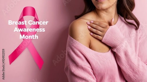 Woman touching her breast, ribbon symbolizing breast cancer, with phrase Breast Cancer Awareness Month, light pink background.
