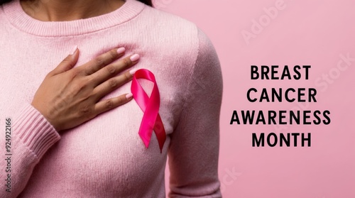 Wallpaper Mural Woman touching her breast, ribbon symbolizing breast cancer, with phrase Breast Cancer Awareness Month, light pink background. Torontodigital.ca