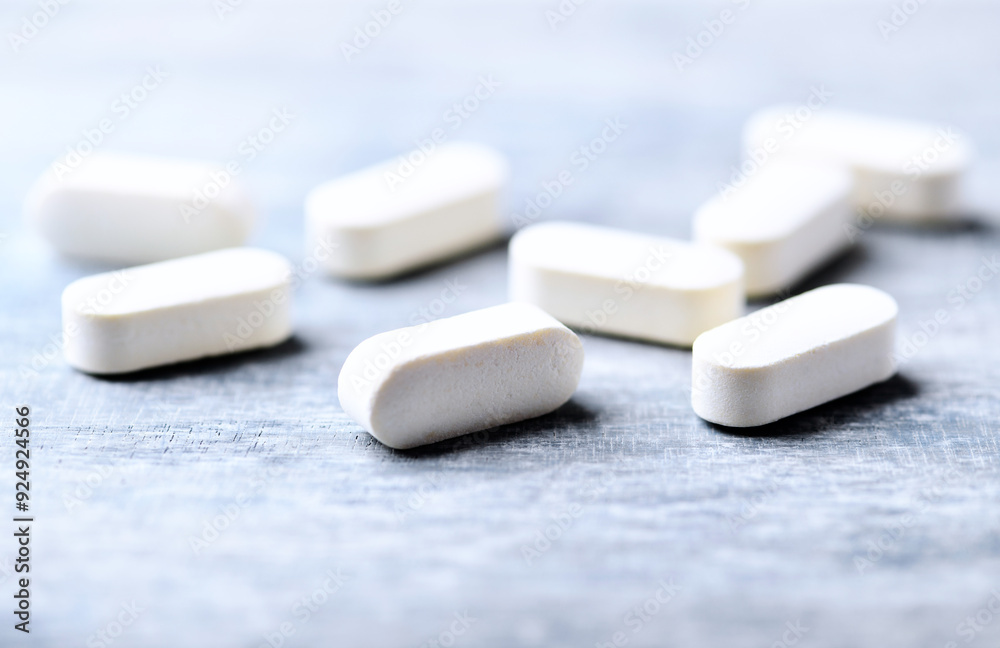 Amino acids tablets. Nutrition for bodybuilding. Fitness supplements on bright wooden background. Soft focus. Copy space. Amino acids tablets. Nutrition for bodybuilding. Fitness supplements on bright wooden background. Soft focus. Copy space.