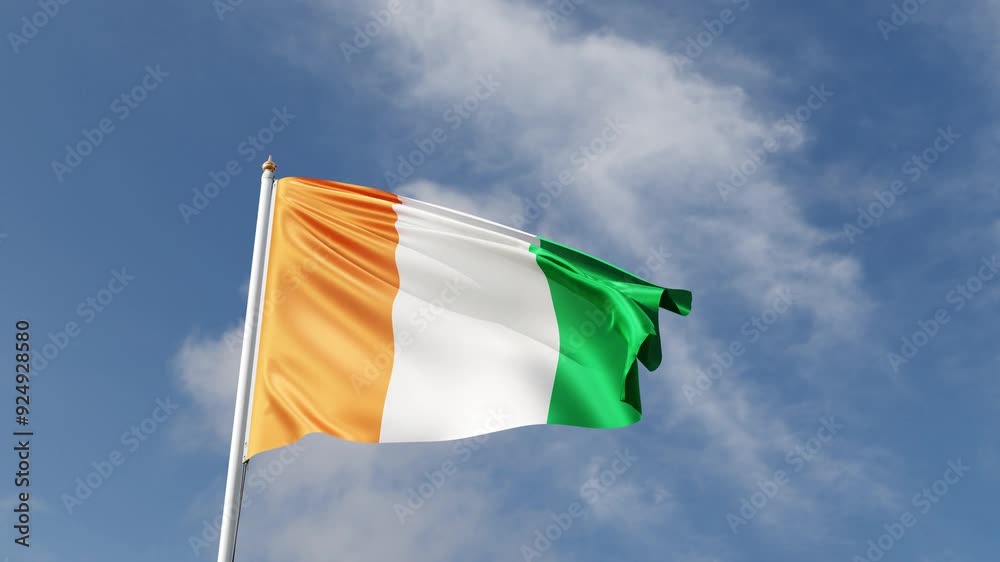 Flag of  cote d'ivoire on a blue sky, flag on a flag pole waving in the wind, african country, national symbol of ivory coast, video of a flag	