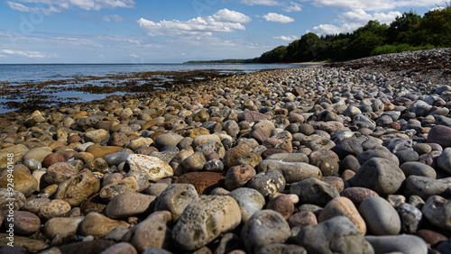 Low angle panorama shot of a pebble beach in late afternoon light