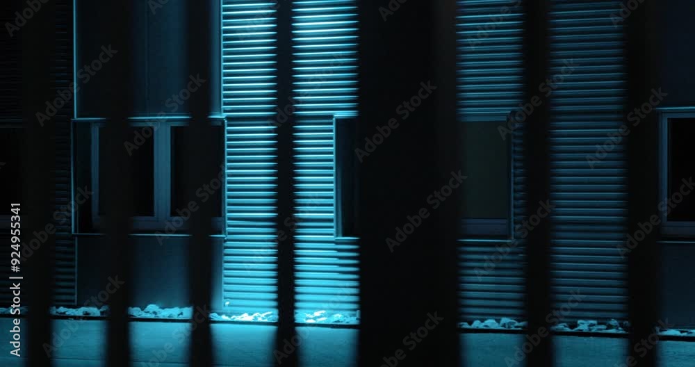 Blau beleuchtetes Gebäude hinter gittern