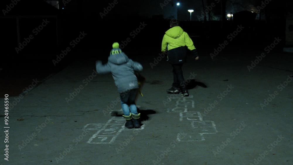 Zwei Kinder springen nachts auf Spielplatz