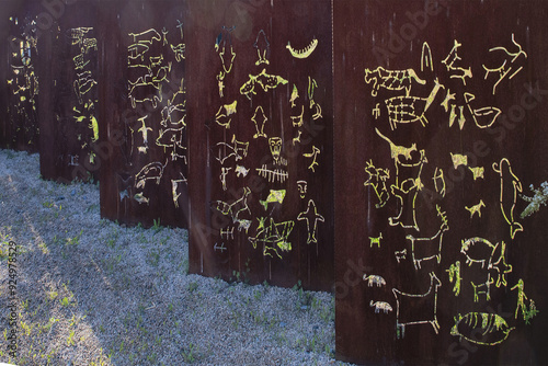 Ulsan, South Korea - April 17, 2022: Close-up of iron plate sculpture with carved Bangudae Petroglyph Rock in a row near Taehwa River photo