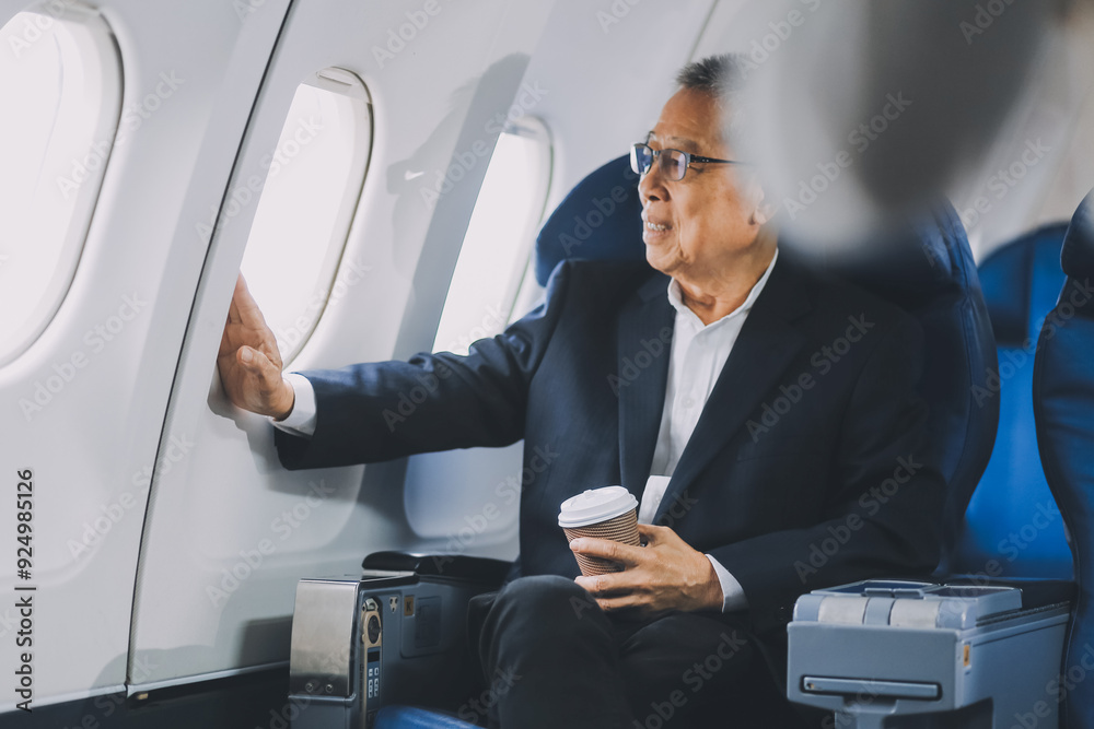 Attractive Asian male passenger of airplane sitting in comfortable seat while working laptop and tablet with mock up area using wireless connection. Travel in style, work with grace. Attractive Asian male passenger of airplane sitting in comfortable seat while working laptop and tablet with mock up area using wireless connection. Travel in style, work with grace.