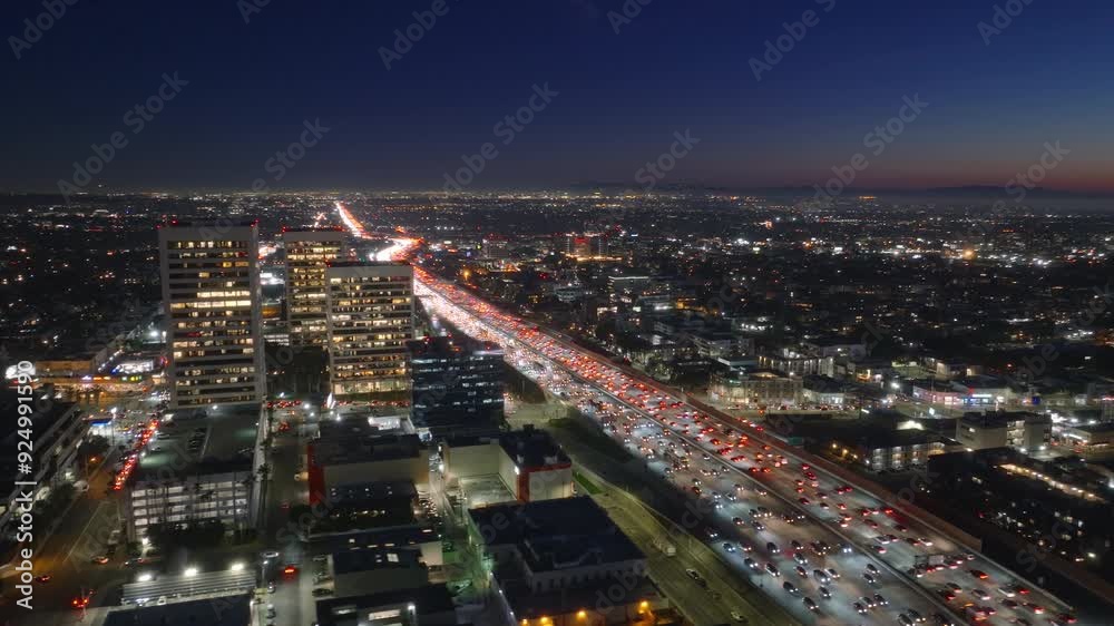Aerial view of a busy nighttime traffic jam in Los Angeles downtown area, illuminated by city lights as cars line the highway, showcasing the metropolitan landscape and urban congestion Aerial view of a busy nighttime traffic jam in Los Angeles downtown area, illuminated by city lights as cars line the highway, showcasing the metropolitan landscape and urban congestion
