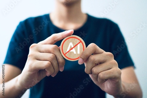Businessman holds a wooden block against artificial intelligence and shows a no ai sign.