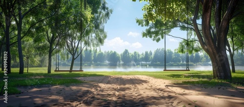 On a sunny day in the park there are two unoccupied swings providing entertainment for visitors with a scenic view in the background as a copy space image photo