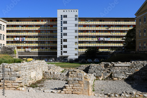 Modern residental building with ancient Roman ruins in the foreground in Pula, Croatia photo