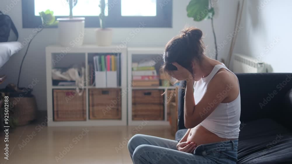 Pregnant woman feeling morning sickness and hormonal discomfort, holding her head in pain. Highlights first-trimester pregnancy symptoms and reproductive health challenges