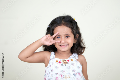  A delightful little girl with sparkling eyes, breaking into a wide, infectious smile. Her expression radiates pure happiness and innocence.