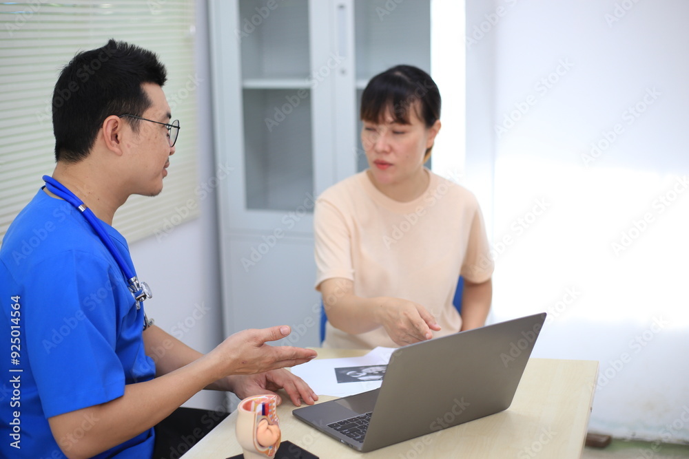 Obraz premium Male doctor with experience examining young pregnant women