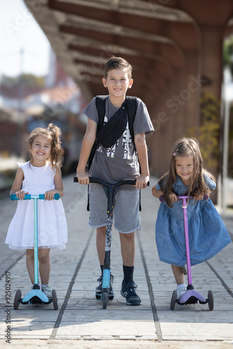 Wallpaper Mural Portrait of a brother with his two little sisters on scooters Torontodigital.ca