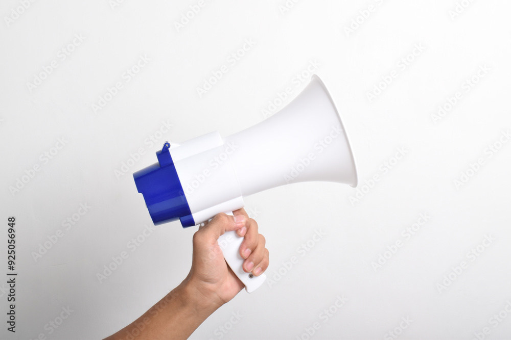Close up hand holding megaphone isolated on white background. Concept of hiring, advertising something. Banner. Copy space Close up hand holding megaphone isolated on white background. Concept of hiring, advertising something. Banner. Copy space