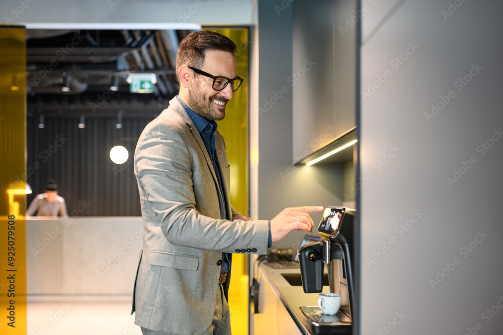 Side view of businessman in eyeglasses brewing coffee with coffeemaker in modern office during break Side view of businessman in eyeglasses brewing coffee with coffeemaker in modern office during break