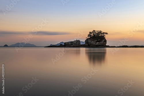 Long exposure and sunset view of Sangjogam County Park with Siru Island on the sea at Deokmyeong Village near Goseong-gun, South Korea photo