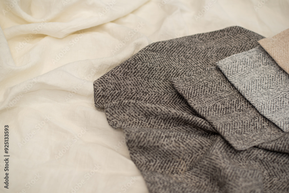 Fototapeta premium Gray textured fabric for curtains close-up. Tissue samples on a milky background.
