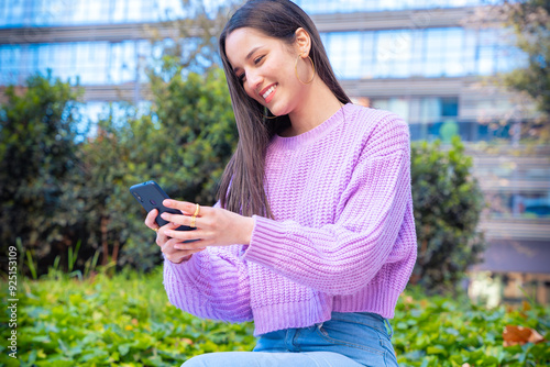 Side view smiling young female using smartphone app outdoors.