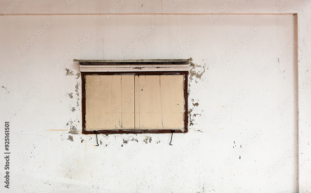Naklejka premium dusty white ancient building facade with the Beige wooden windows.
